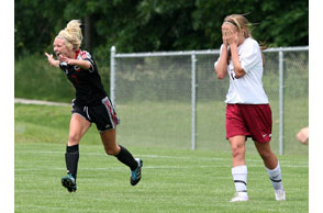 REASON TO CELEBRATE: Troy's Kayla Porter (No. 2 on left) races towards her teammates after scoring the game-winning goal while Grandville's Elise Royer walks away in agony during Saturday's Division 1 state championship match. Photon | Larry McKee, lmckeephotography.com, lmckeephotography@comcast.net