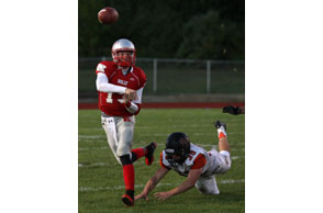 JUST IN TIME: Holly quarterback Jake thorn gets off this pass just before being hit by Fenton's Ben Curtis during Friday's Flint Metro League game.Photo | Larry McKee, www.lmckeephotography.com, lmckeephotography@comcast.net